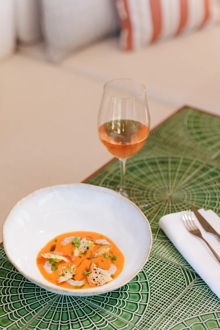 Chilled tomato soup with prawns on a green tiled table