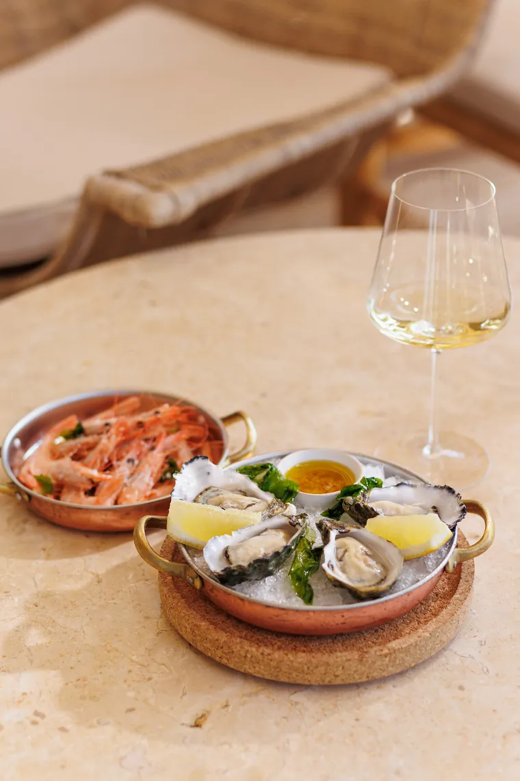 Oysters and prawns on ice with a glass of white wine