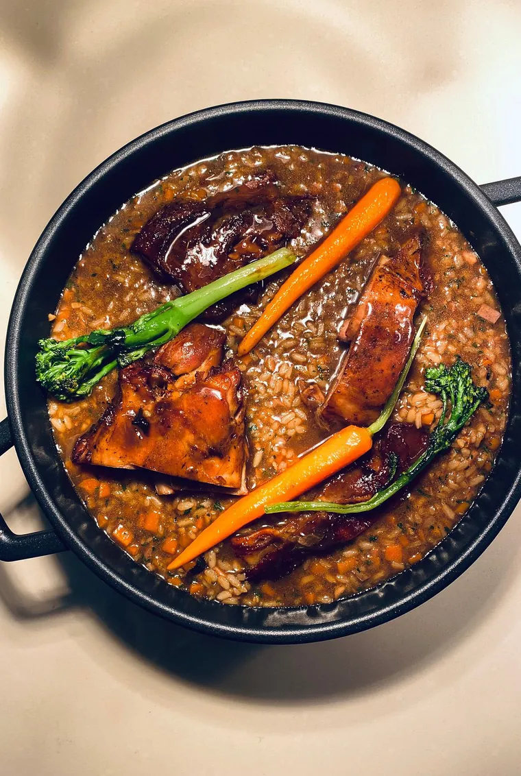 Seared scallops in a shellfish broth on black marble