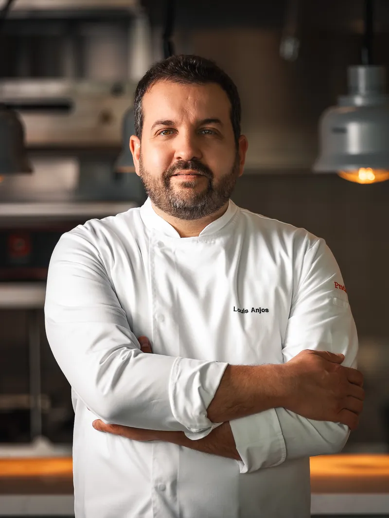 Chef Louis Anjos under the pass lamps of his kitchen