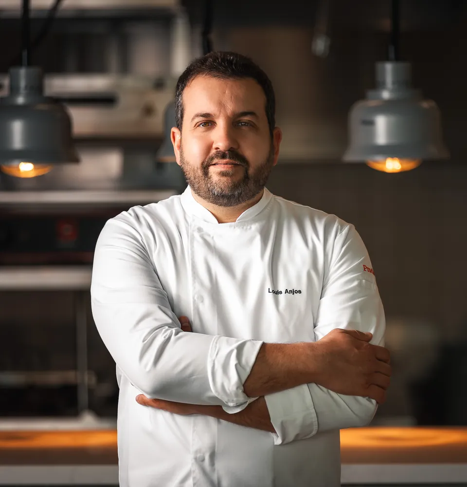 Chef Louis Anjos under the pass lamps of his kitchen