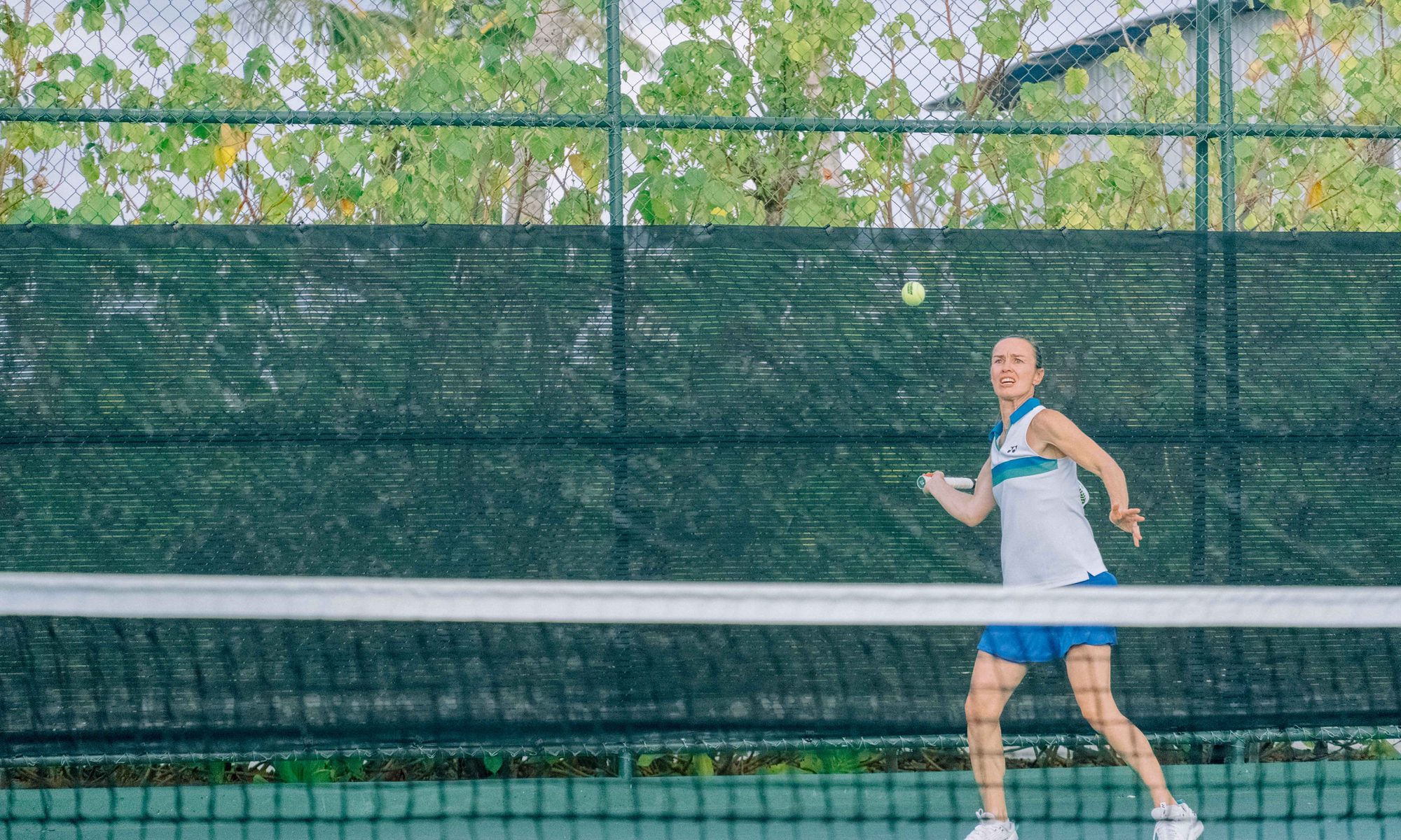 Martina Hingis playing a forehand on a green hard court